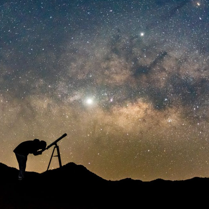 A person observing the night sky through one of the best telescopes